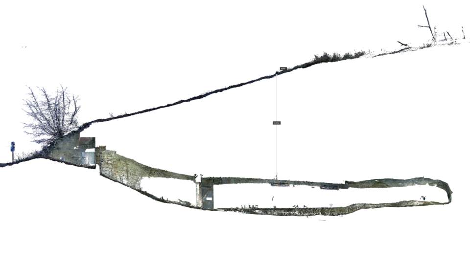 Das Bild zeigt ein digitales 3D-Modell eines Geländes mit einem unterirdischen Bauwerk. In der Mitte ist ein länglicher Tunnel dargestellt, der sich unter einer geneigten Erdoberfläche erstreckt. Links befindet sich ein Eingangsbereich mit einer kleinen Struktur, während rechts die Tunnelöffnung weiter verläuft. Über dem Tunnel ist eine senkrechte Linie mit einer Maßangabe zu sehen, die vermutlich die Tiefe oder Position eines geplanten Belüftungsschachts markiert.