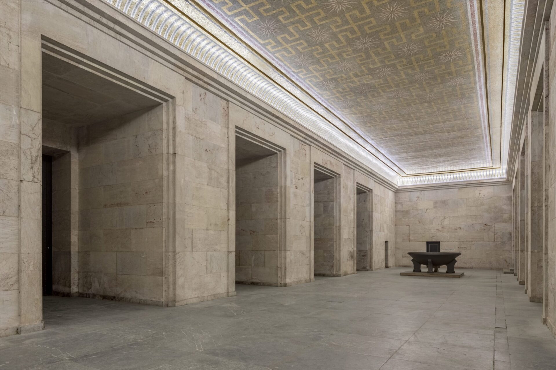 Innenraum der Zeppelintribüne mit monumentaler Natursteinarchitektur, hohen Säulen und der restaurierten Goldmosaikdecke im ehemaligen Goldenen Saal.