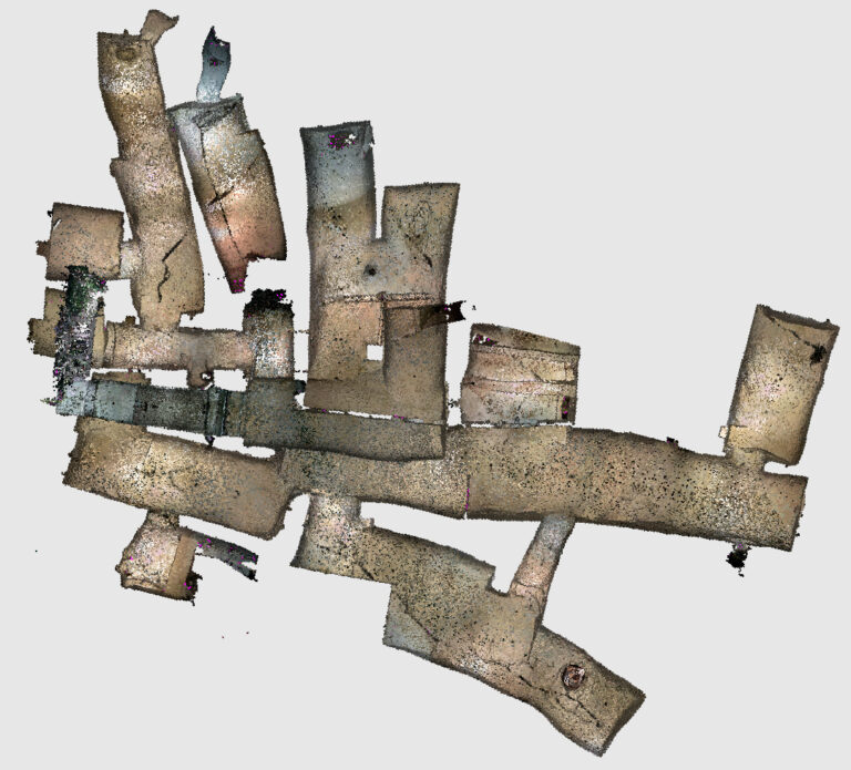Das Bild zeigt eine digitale 3D-Punktwolken-Darstellung eines unterirdischen Gang- und Raumsystems in Draufsicht. Mehrere schlauchförmige, unregelmäßig verlaufende Gänge sind miteinander verbunden und bilden ein verzweigtes Netzwerk. Die Oberflächen wirken körnig und gesprenkelt, typisch für eine aus Laserscandaten erzeugte Struktur.